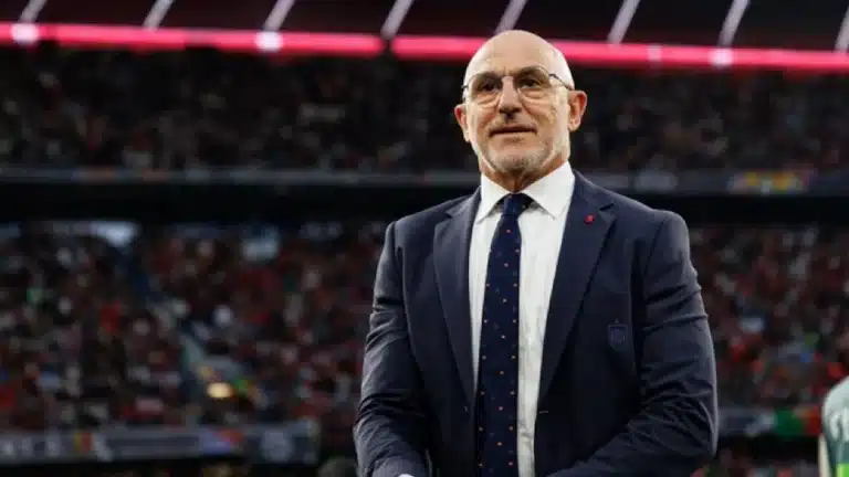 Luis de la Fuente, con traje oscuro y el escudo de la RFEF en la solapa, observa el terreno de juego desde la banda