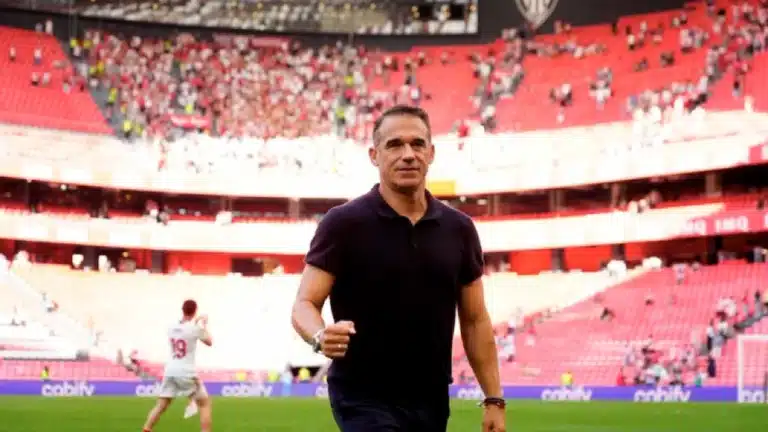 Luis García Plaza camina sonriente por el césped de San Mamés con la grada rojiblanca al fondo