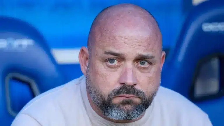 Manolo Gonzalez sentado en el banquillo del RCDE Stadium con el fondo de asientos azules del estadio