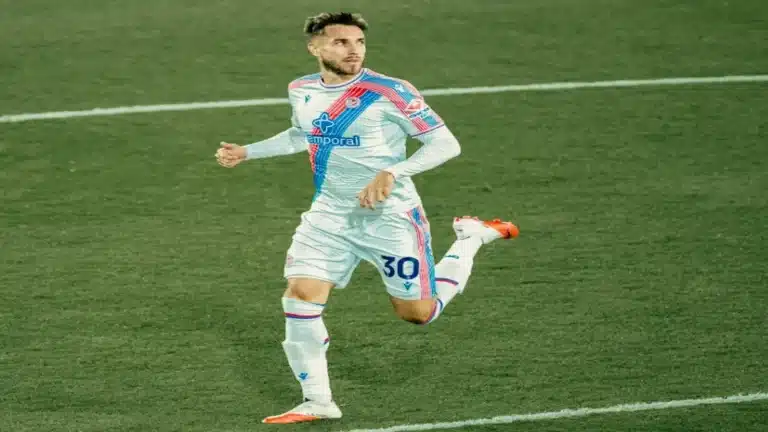 Óscar Mingueza corre con la camiseta blanca del Crystal Palace y el dorsal 30 durante un partido de Premier League