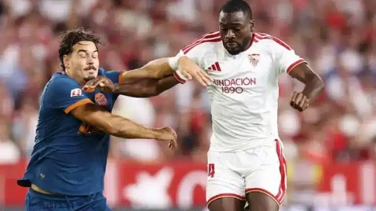 Youssouf Fofana, con la camiseta blanca del Sevilla, se zafa del agarrón de un jugador del Valencia en el Sánchez-Pizjuán